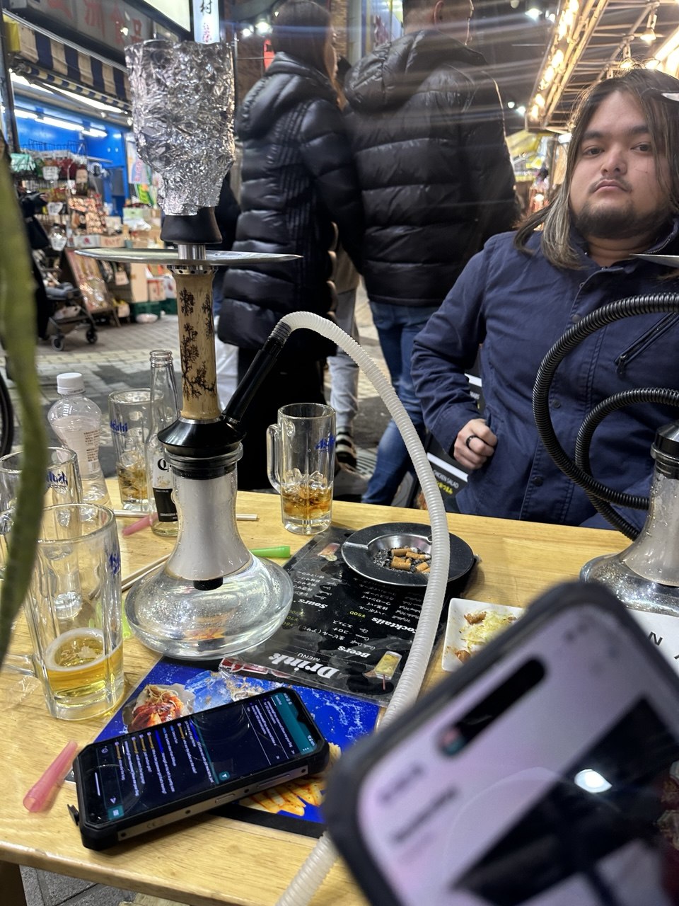 Gäste in einer Tokioter Kneipe an einem Tisch mit Shishas aus Michael Rosenfelds Amazon-Brand